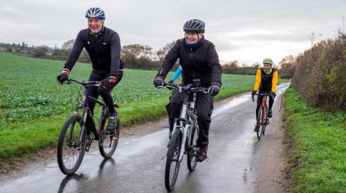 Cyclists riding along a road in the Norfolk countryside